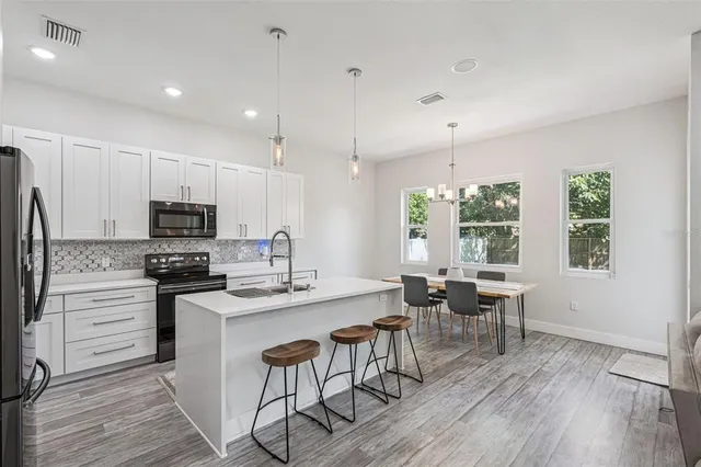 a kitchen with appliances a sink and cabinets