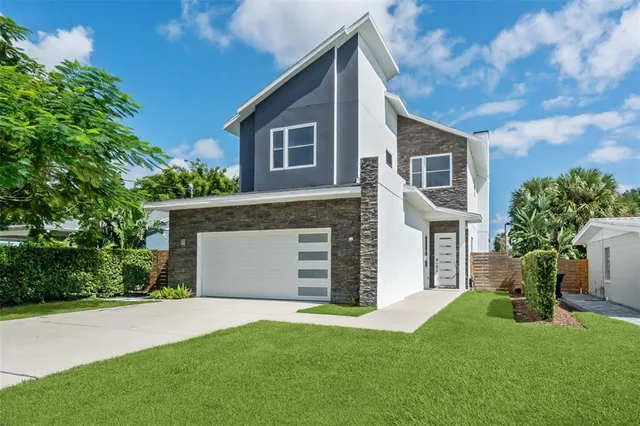 a front view of a house with a garden and yard