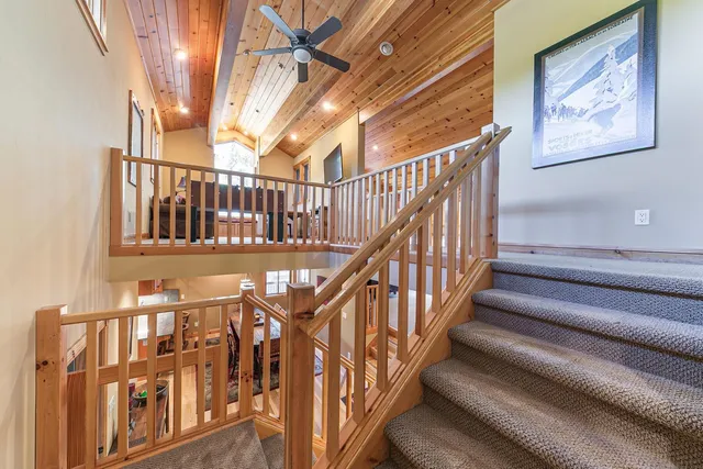 a view of staircase with lots of frames on wall and a window