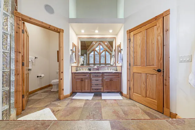 a bathroom with a double vanity sink a mirror and a bathtub