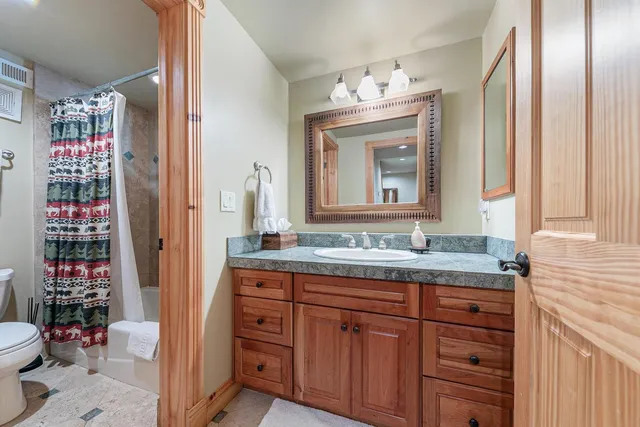 a bathroom with a granite countertop sink and a mirror