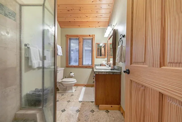 a bathroom with a granite countertop sink toilet and shower