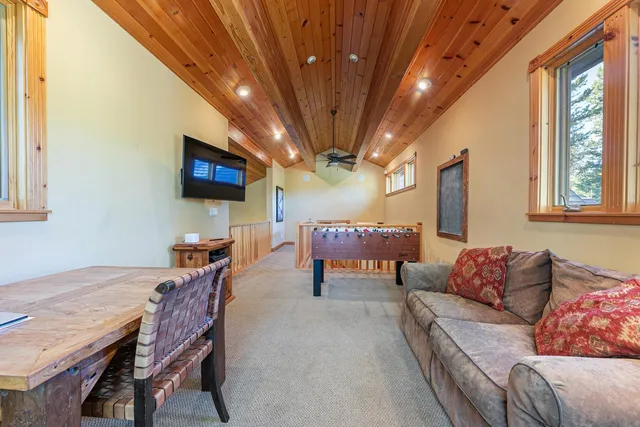 a living room with furniture a flat screen tv and a large window