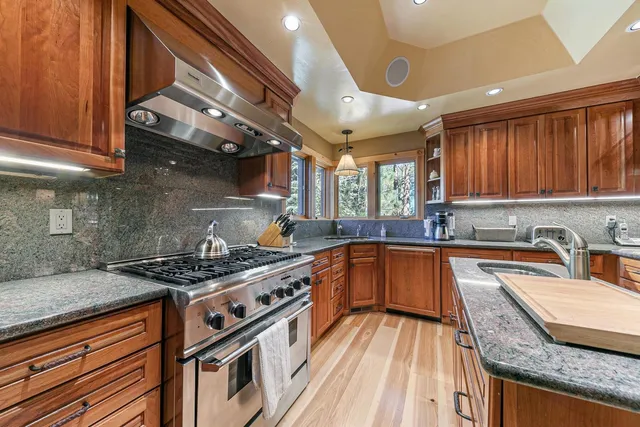a kitchen with stainless steel appliances granite countertop a stove and a sink
