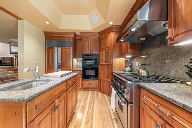a kitchen with stainless steel appliances granite countertop a sink stove and cabinets