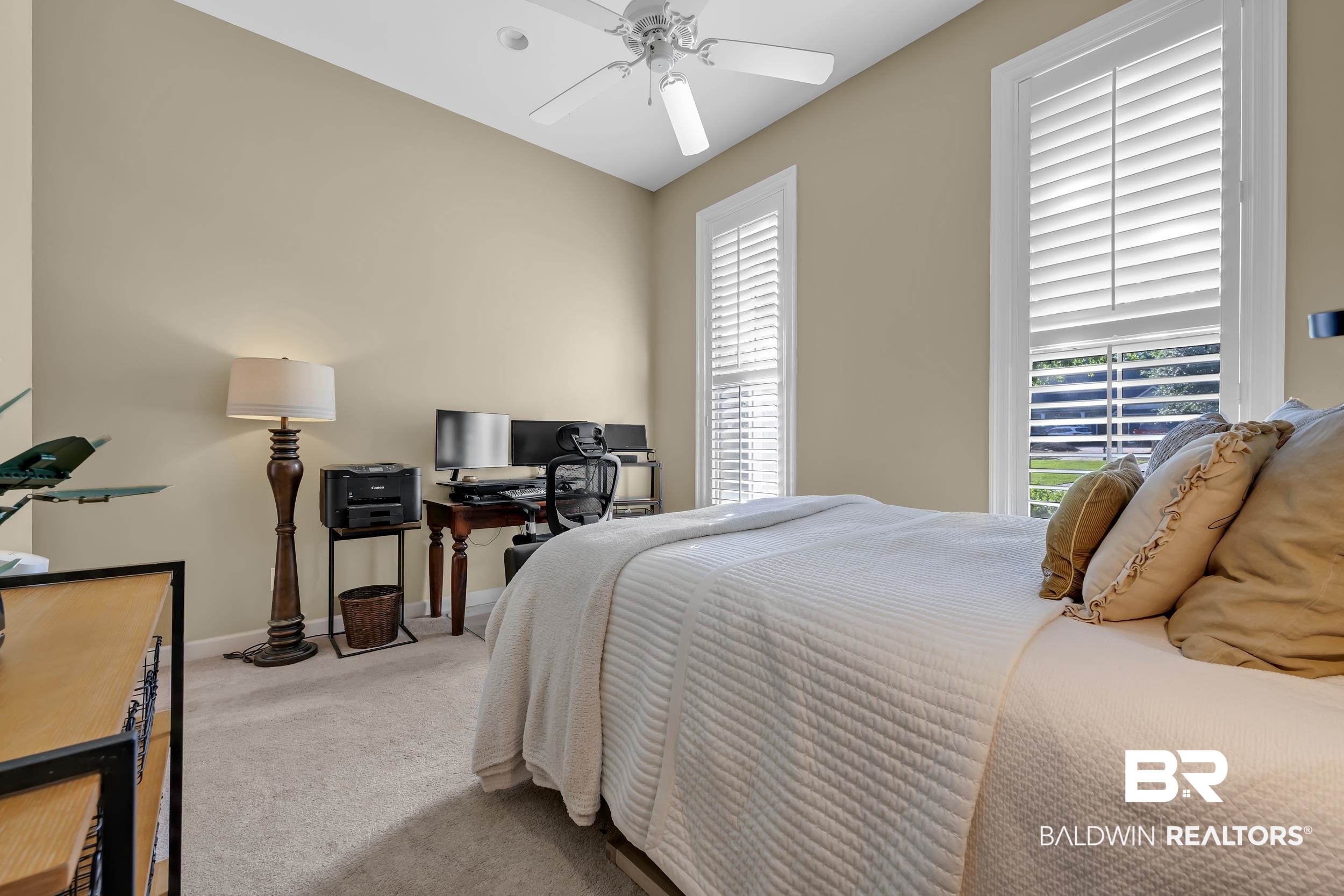 8137 Pine Run Daphne, AL 36527 - Photo 34 of 67 Carpeted room featuring two tall windows with white plantation shutters, a ceiling fan, and light beige wall paint