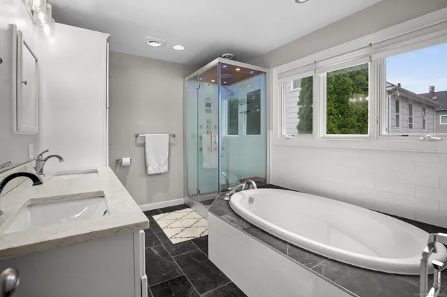 a bathroom with a tub sink and mirror