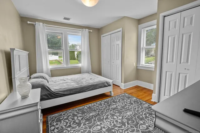 a bedroom with a bed and wooden floor