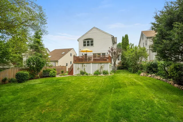 a view of a house with a big yard and large trees
