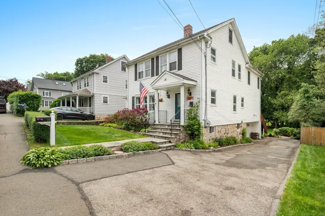 a view of a white house with a yard and plants