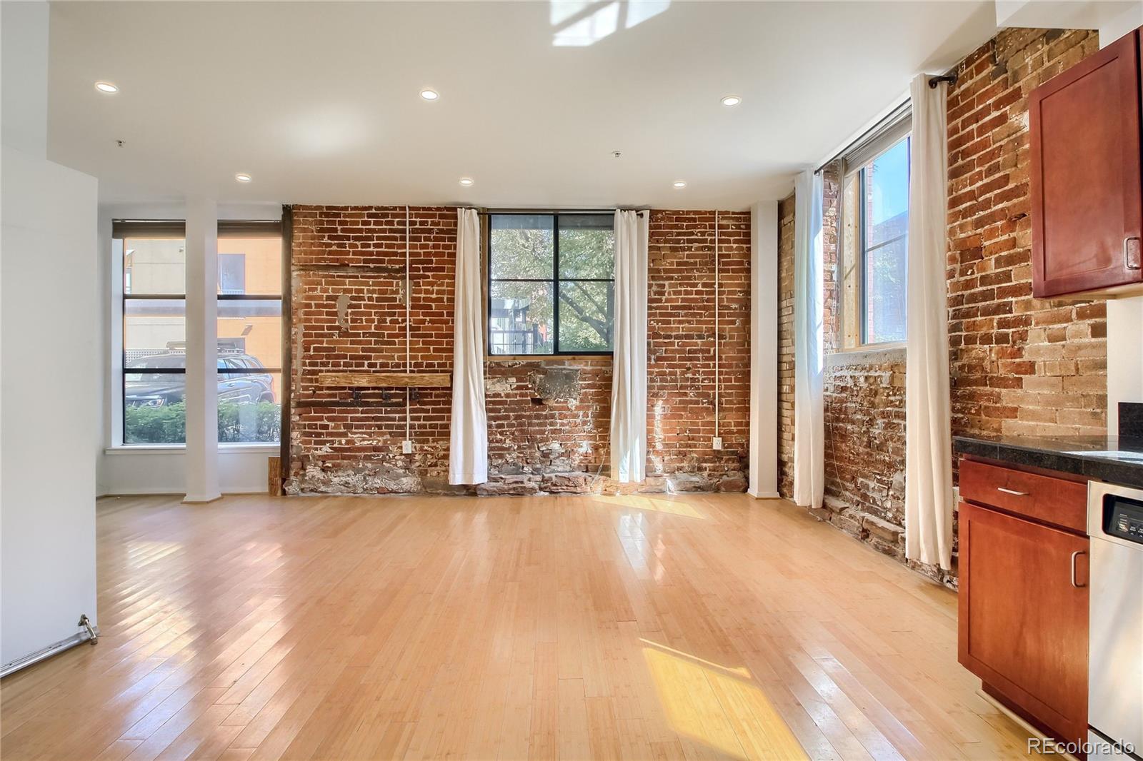 3225 Blake Street, Unit 2 Denver, CO 80205 - Photo 12 of 31 a view of an empty room with a window and wooden floor