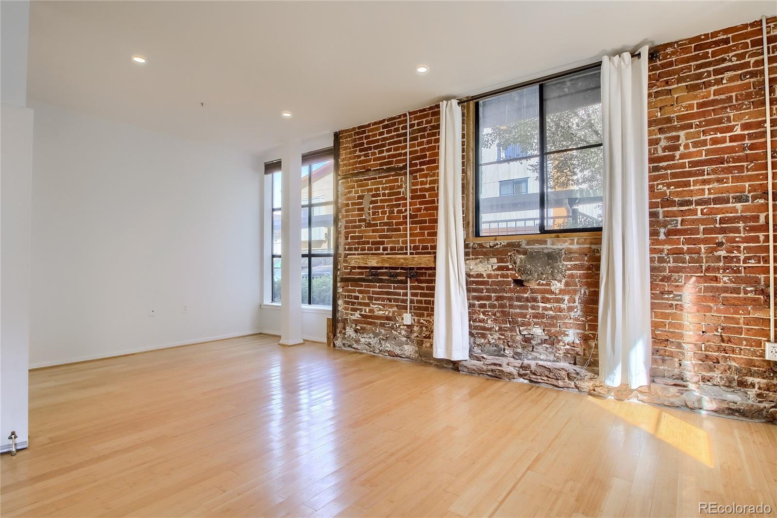 3225 Blake Street, Unit 2 Denver, CO 80205 - Photo 15 of 31 an empty room with wooden floor and windows