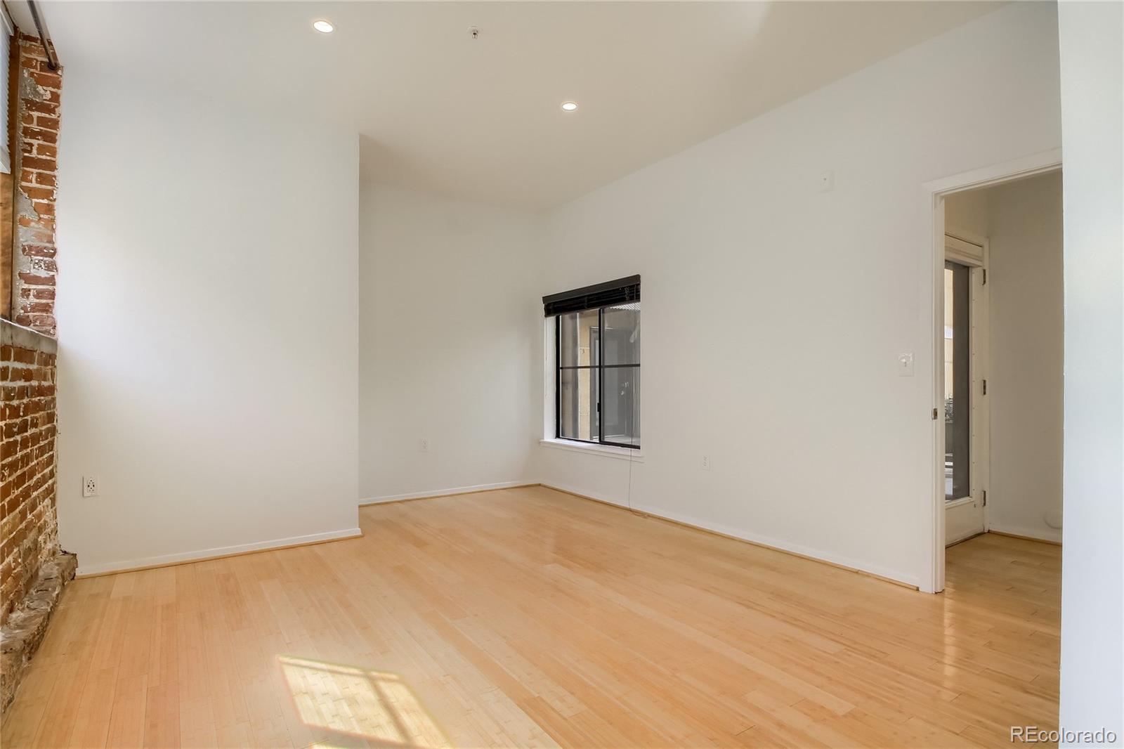 3225 Blake Street, Unit 2 Denver, CO 80205 - Photo 22 of 31 a view of an empty room with wooden floor and a window