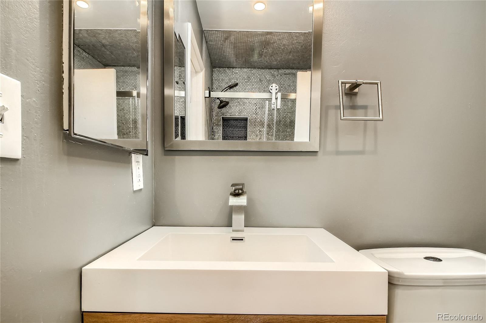 3225 Blake Street, Unit 2 Denver, CO 80205 - Photo 25 of 31 a bathroom with a sink a toilet and mirror