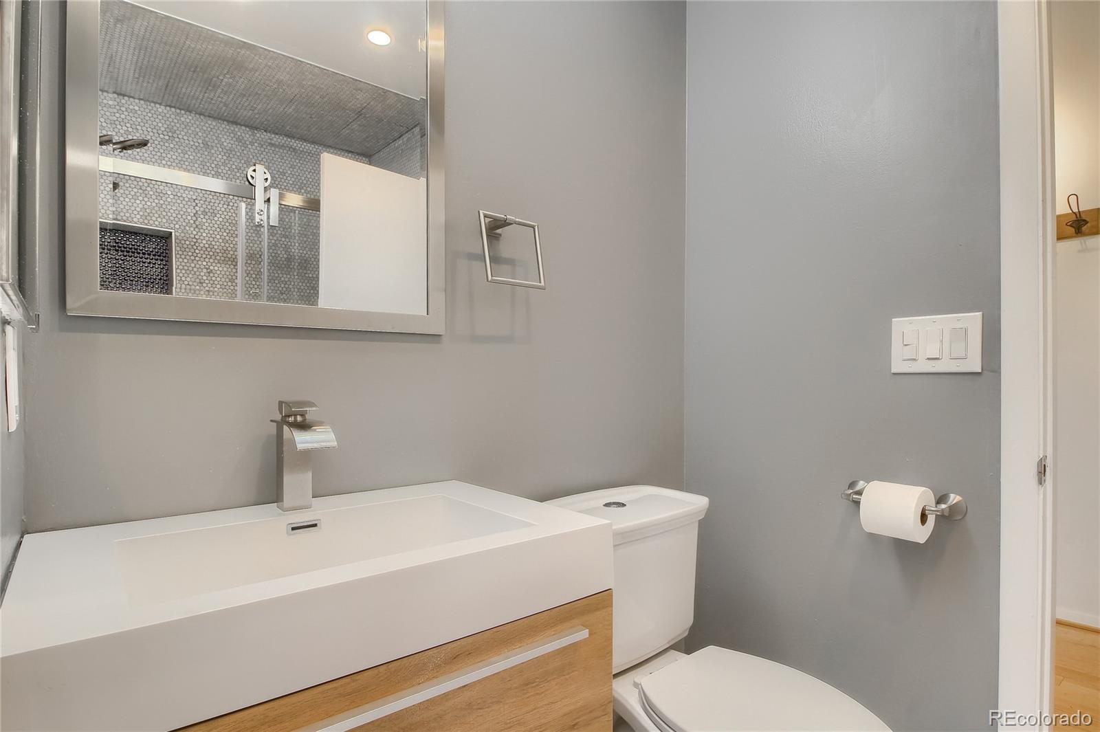 3225 Blake Street, Unit 2 Denver, CO 80205 - Photo 26 of 31 a bathroom with a sink mirror and toilet