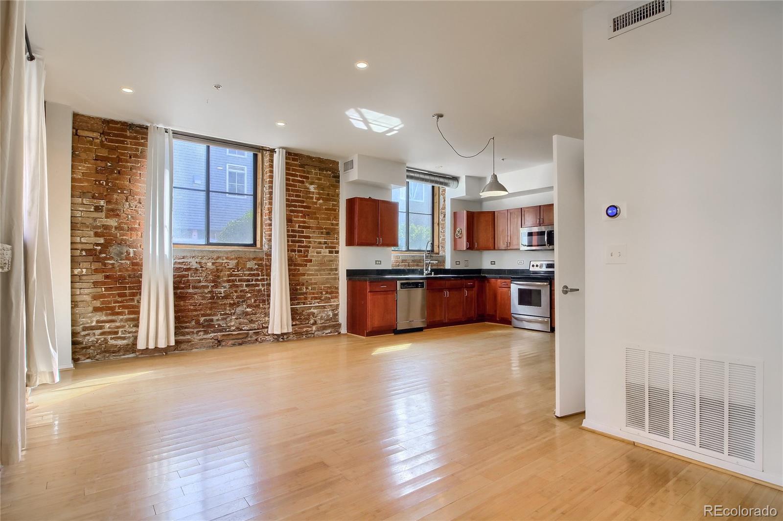 3225 Blake Street, Unit 2 Denver, CO 80205 - Photo 4 of 31 a view of kitchen with kitchen island granite countertop wooden cabinets and a sink