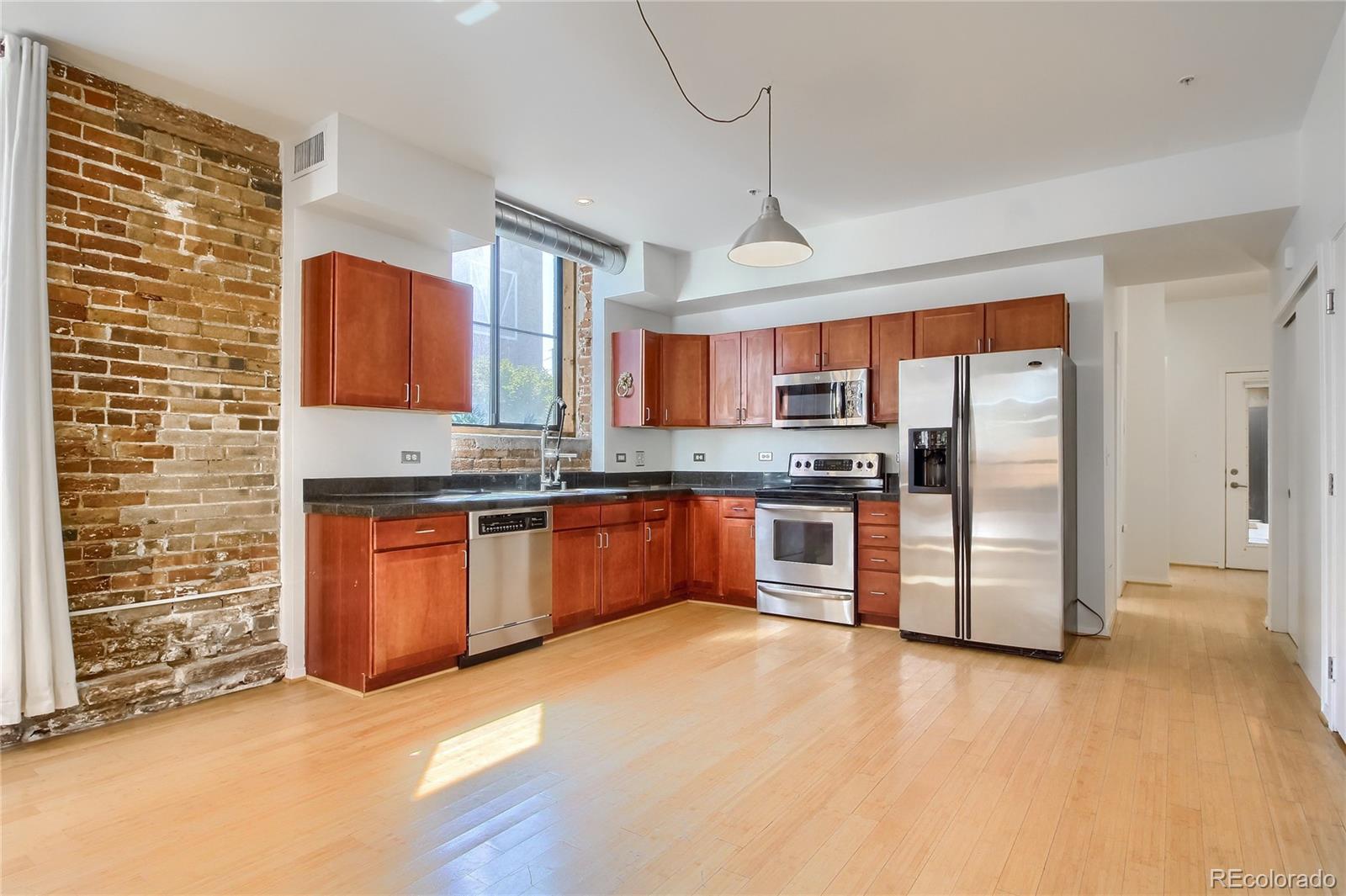 3225 Blake Street, Unit 2 Denver, CO 80205 - Photo 6 of 31 a kitchen with stainless steel appliances granite countertop a refrigerator and a stove top oven