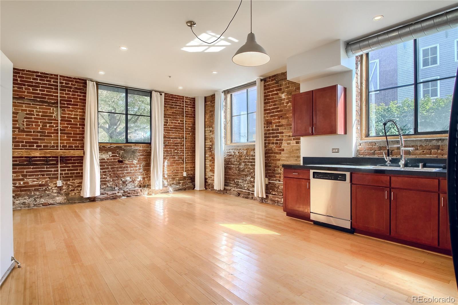 3225 Blake Street, Unit 2 Denver, CO 80205 - Photo 7 of 31 a view of a kitchen with granite countertop a stove top oven a sink and wooden floor
