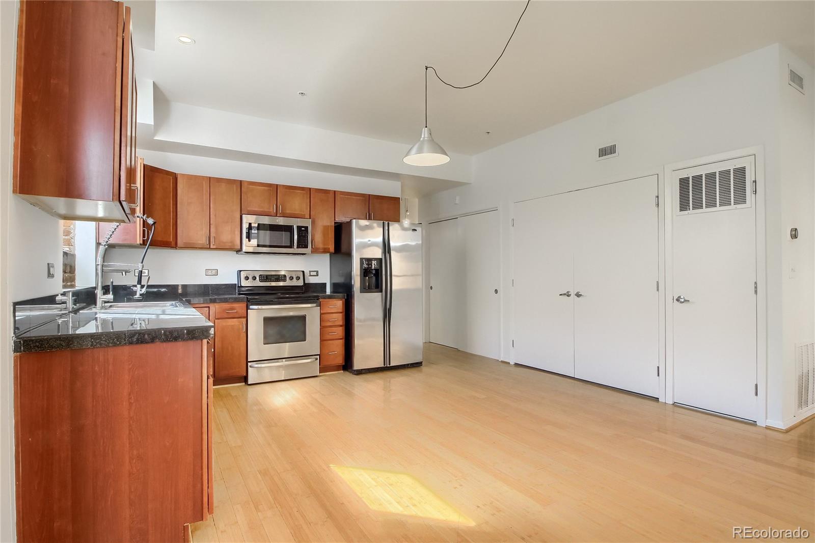 3225 Blake Street, Unit 2 Denver, CO 80205 - Photo 9 of 31 a kitchen with stainless steel appliances granite countertop a stove a sink dishwasher a refrigerator and a microwave oven