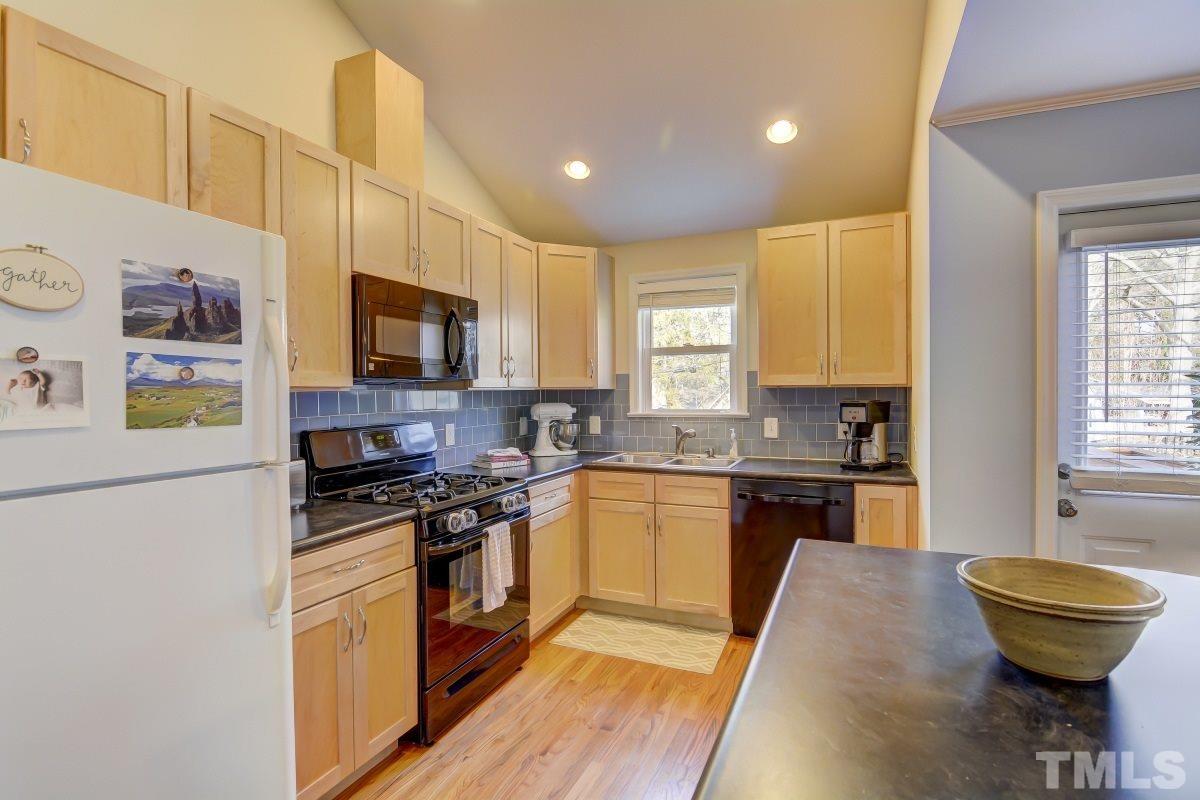 1719 Bennett Street Raleigh, NC 27604 - Photo 7 of 18 a kitchen with stainless steel appliances granite countertop a stove a sink and a refrigerator