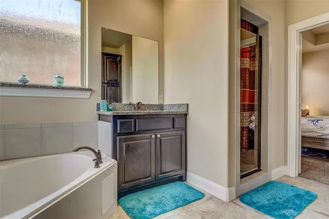 a bathroom with a tub sink and mirror