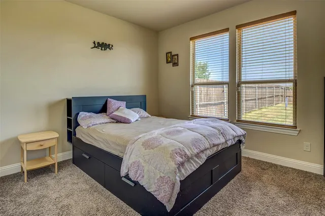 a bed sitting in a bedroom next to a window