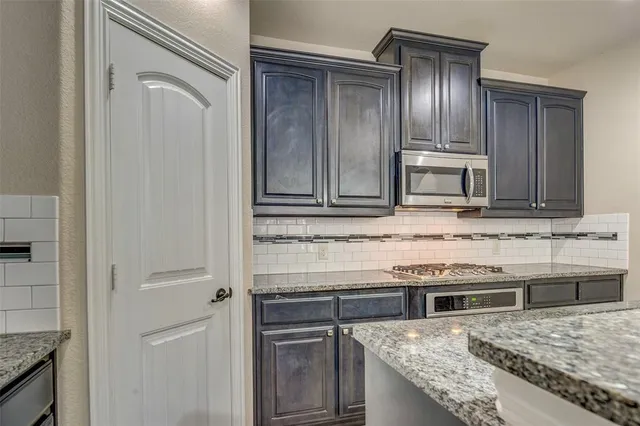a kitchen with granite countertop cabinets stainless steel appliances and a sink