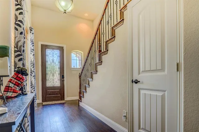 a view of a hallway with wooden floor and stairs