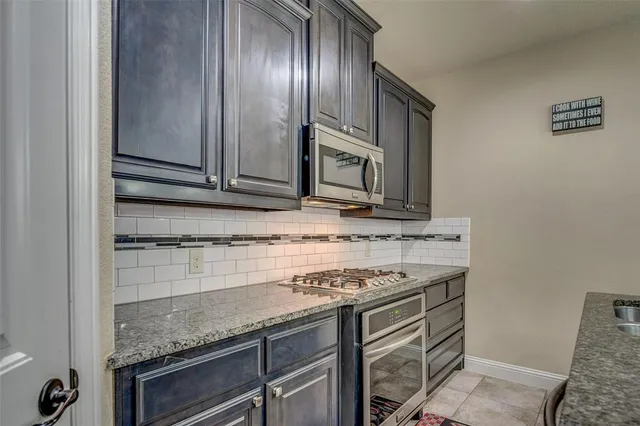 a kitchen with granite countertop cabinets stainless steel appliances and a sink