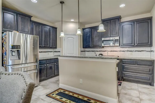 a kitchen with stainless steel appliances granite countertop a refrigerator sink and cabinets