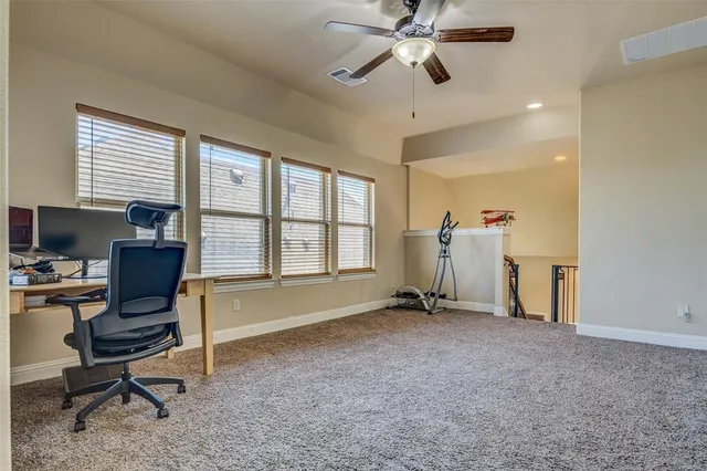a view of a workspace with furniture and a window