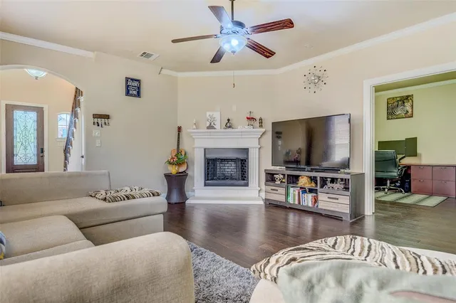 a living room with furniture a flat screen tv and a fireplace