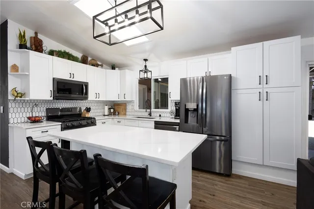 a kitchen with stainless steel appliances a stove a microwave a sink and cabinets