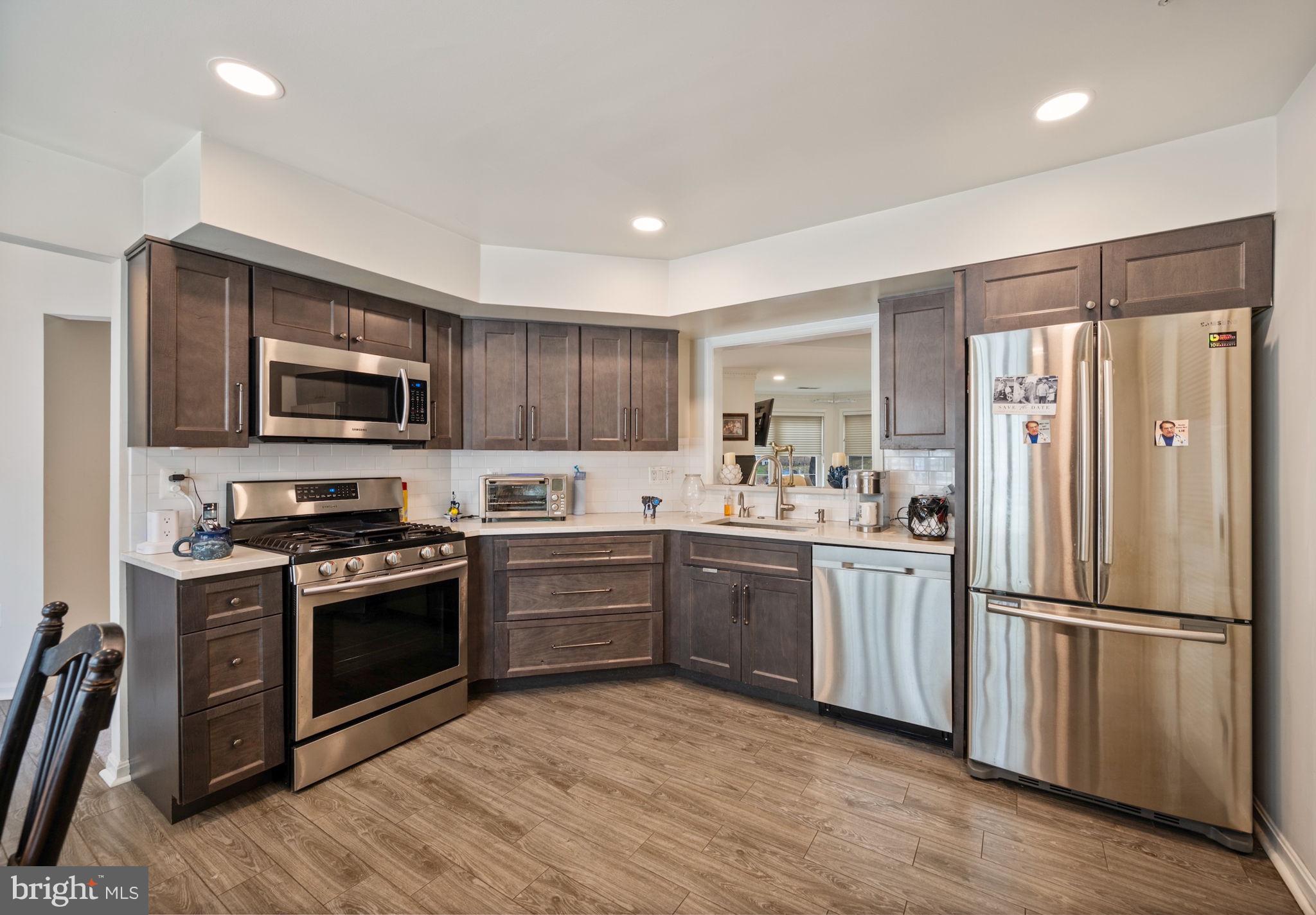 9136 Ruth Elder Lane, Unit 9136 Pikesville, MD 21208 - Photo 2 of 11 a kitchen with granite countertop stainless steel appliances and wooden cabinets