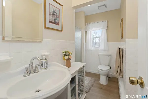 a bathroom with a sink mirror vanity and toilet