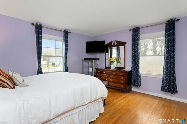 a bedroom with a bed lamps and wooden floor