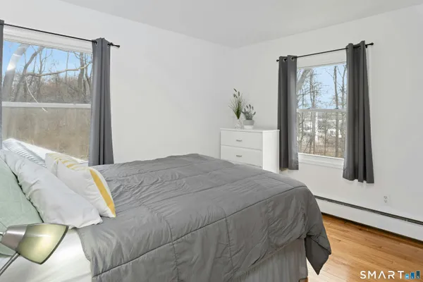 a bedroom with a bed and wooden floor