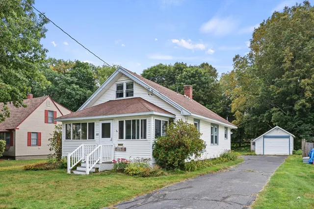a front view of a house with a garden and yard