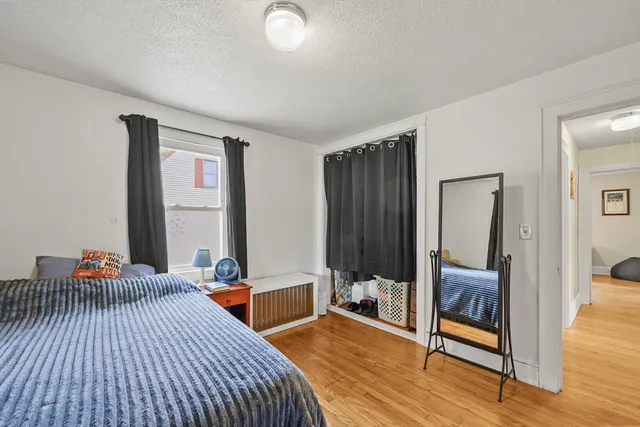a bedroom with a bed and wooden floor