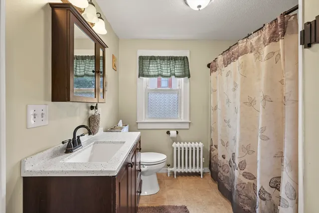 a bathroom with a sink a toilet and a window