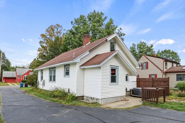 a view of a house with a yard and potted plants