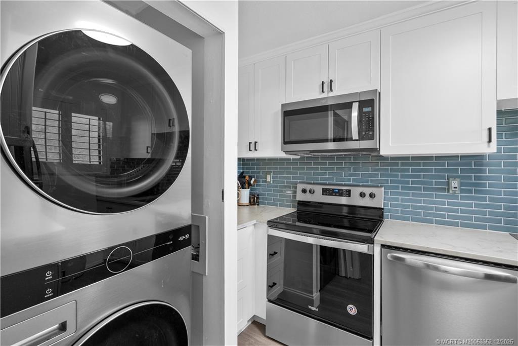 5313 Southeast Miles Grant Road, Unit K209 Stuart, FL 34997 - Photo 15 of 34 a kitchen with granite countertop a stove and a microwave