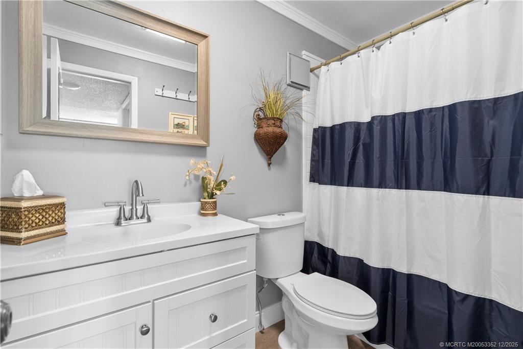 5313 Southeast Miles Grant Road, Unit K209 Stuart, FL 34997 - Photo 18 of 34 a bathroom with a toilet a sink and mirror
