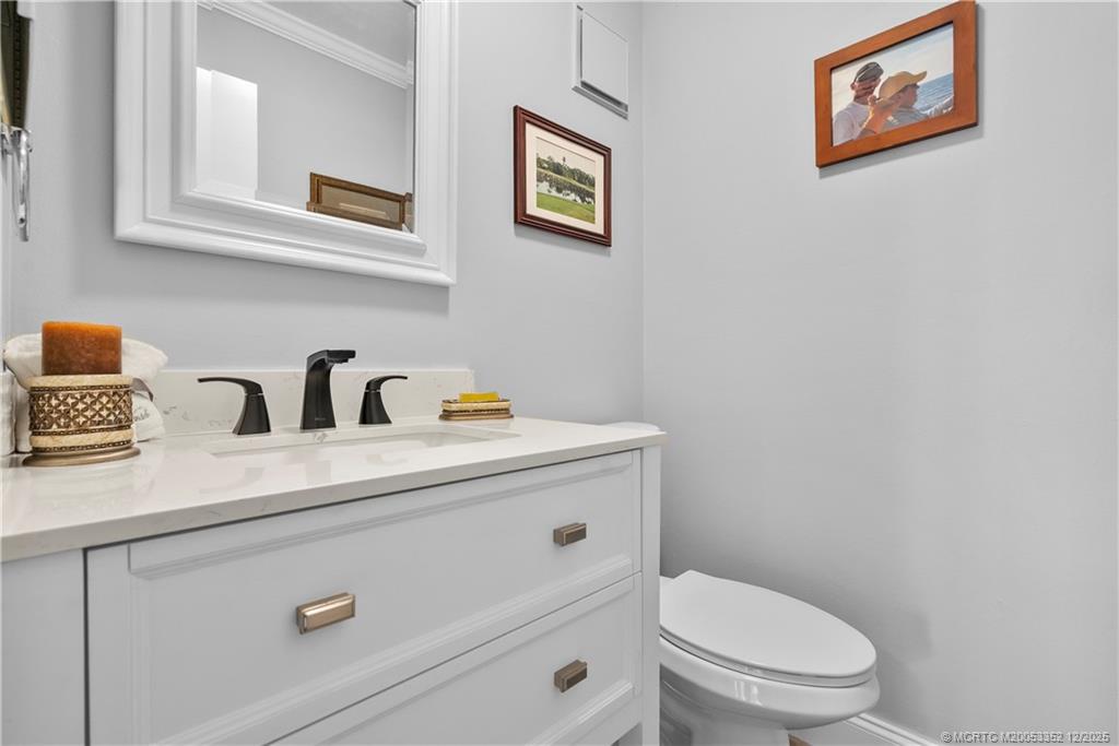 5313 Southeast Miles Grant Road, Unit K209 Stuart, FL 34997 - Photo 19 of 34 a bathroom with a toilet a sink and mirror