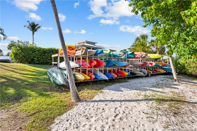 a view of swimming pool with lawn chairs and plants