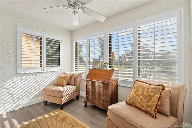 a living room with furniture a flat screen tv and a floor to ceiling window