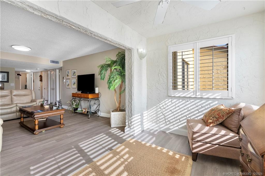 5313 Southeast Miles Grant Road, Unit K209 Stuart, FL 34997 - Photo 5 of 34 a spacious bedroom with a bed and a flat screen tv