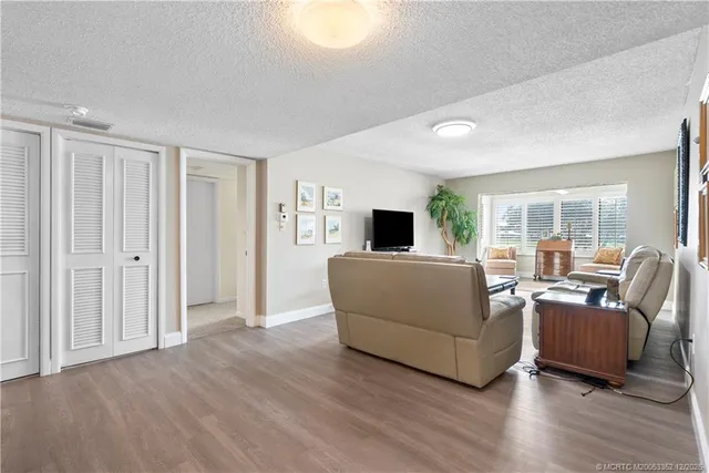 a view of a big room with wooden floor and windows