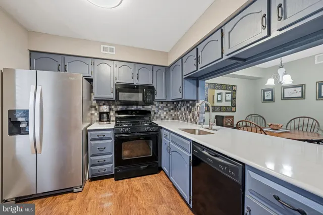 a kitchen with stainless steel appliances a sink stove refrigerator and cabinets