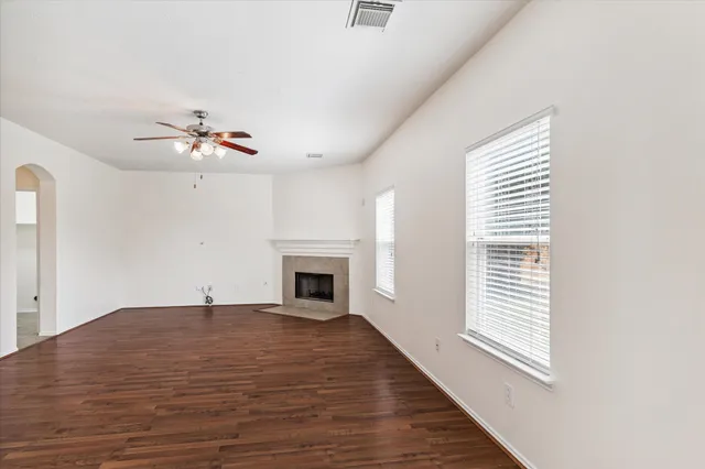 a view of an empty room with a fireplace and a window